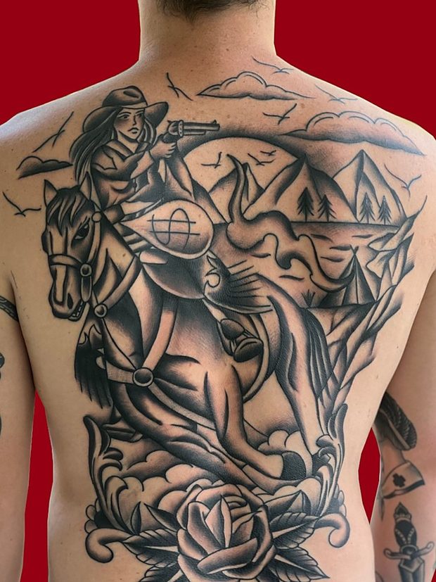 Black and grey full back tattoo of a cowboy on horseback by Penny Boy — large-scale black-and-grey back piece