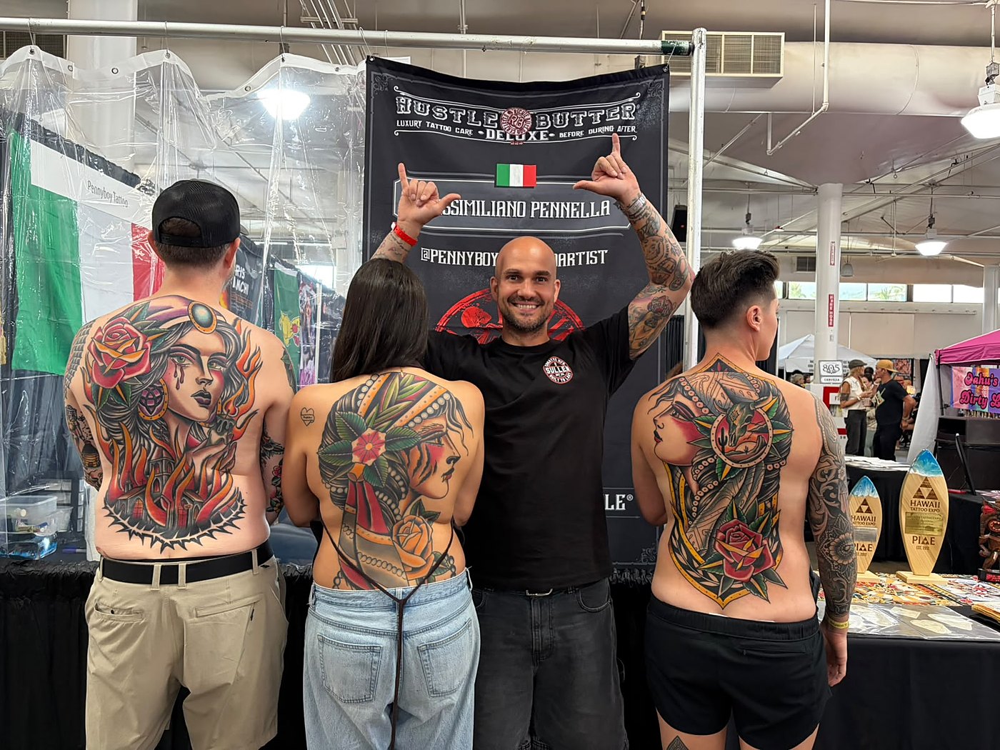 Penny Boy with clients and trophies at a tattoo arts festival
